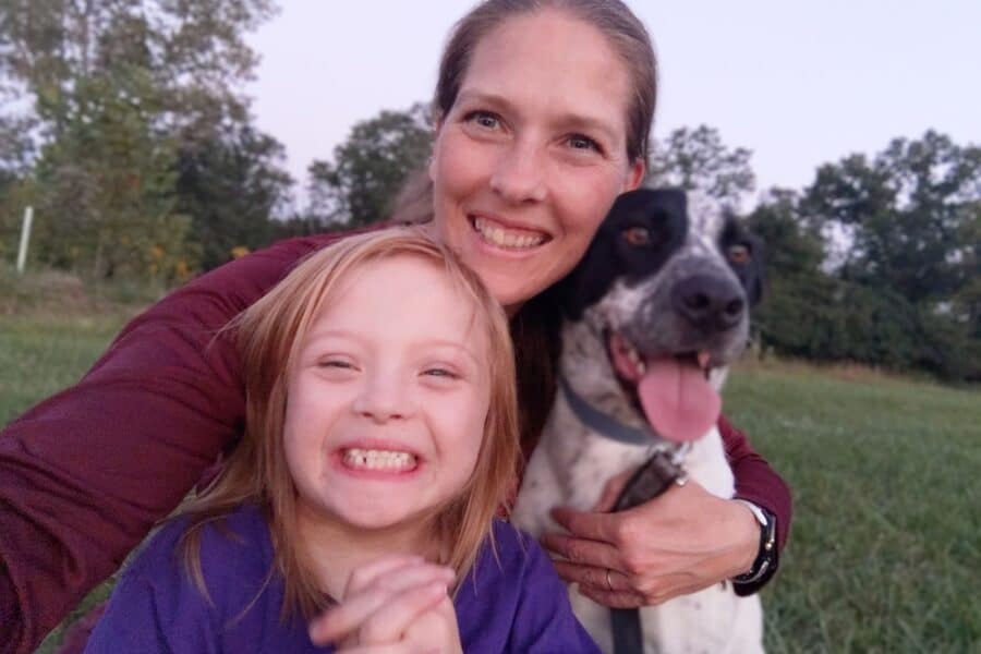 Woman, dog and girl with Down syndrome